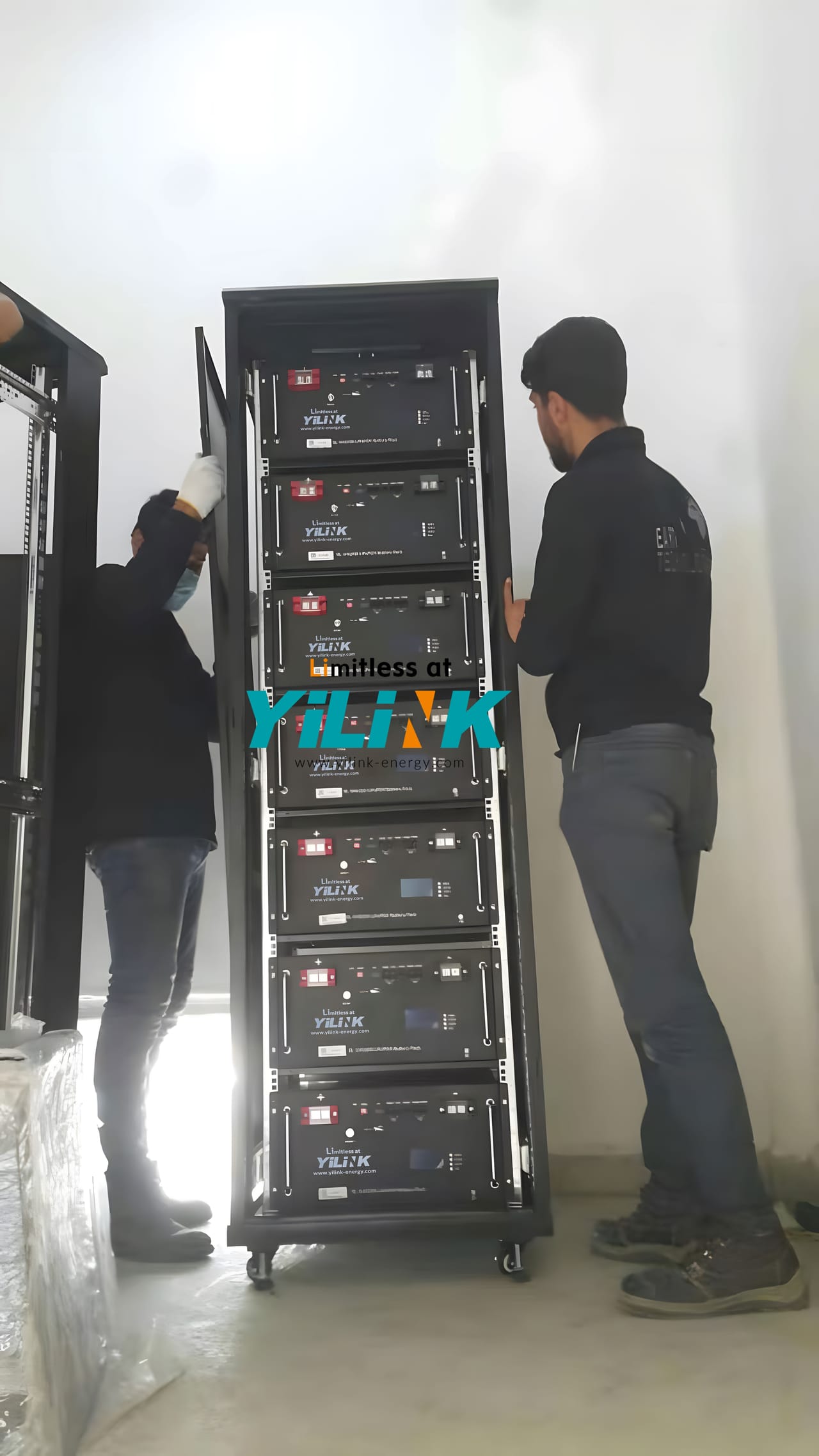Two technicians assembling a 70 kWh Yilink battery rack